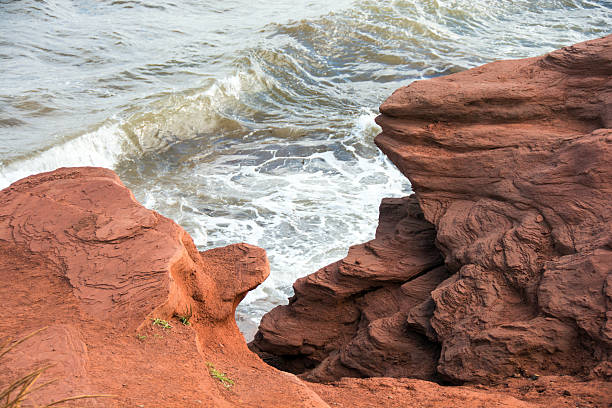 The shoreline at Cavendish in Prince Edward Island National Park The shoreline at Cavendish in Prince Edward Island National Park. The red rocks and sand are natural phenomenonsin the park. September cavendish beach stock pictures, royalty-free photos & images