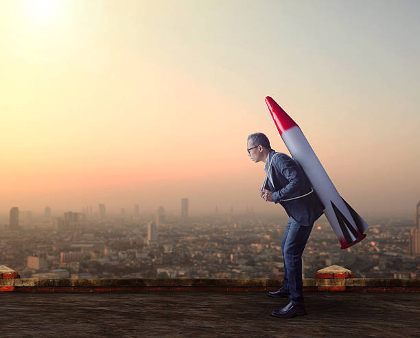 istock business man carries rocket missile on high building 618754608