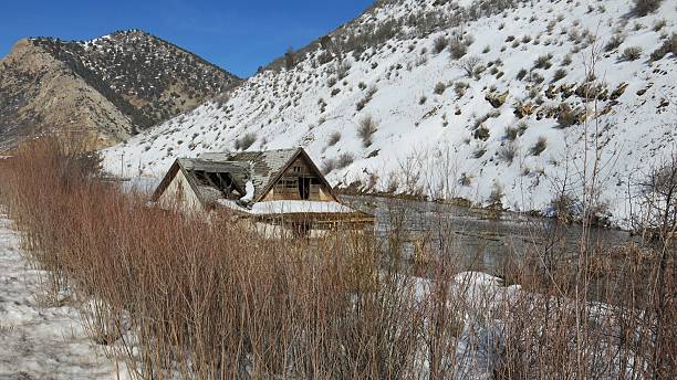 Ruins of a multi-story residential building in the abandoned town of Enilchek surrounded by mountains