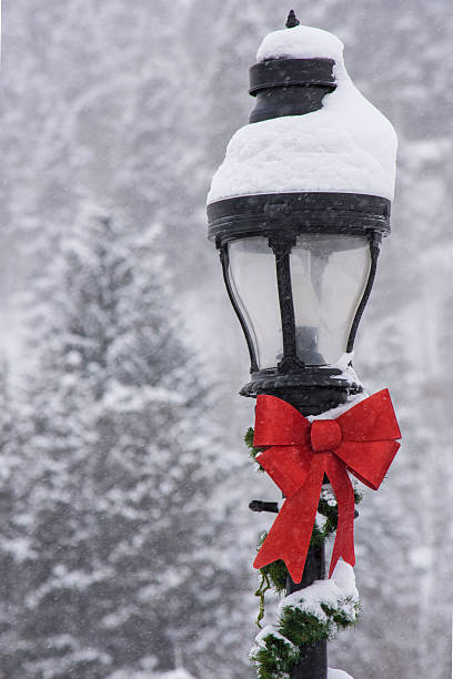 A lamp post decorated for Christmas and covered in snow