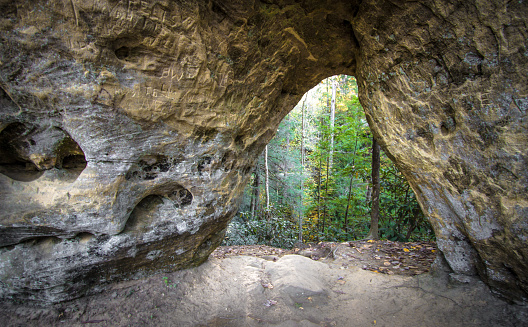 The Angels Window sandstone arch frames the lush forest vegetation of the southeastern Kentucky forest. The arch is located in the Red River Gorge recreation area of the Daniel Boone National Forest in eastern Kentucky. 