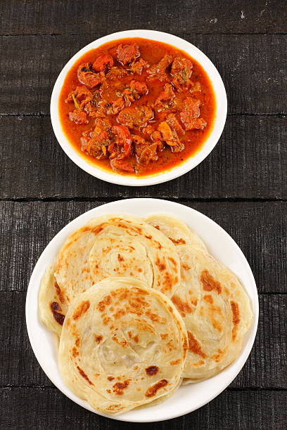 Indian street food paratha served with spicy mutton curry Overhead view-Indian street food paratha served with spicy mutton curry taftan stock pictures, royalty-free photos & images