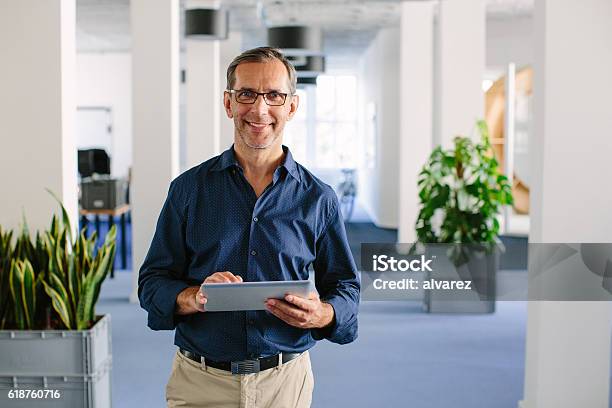 Successful Senior Businessman Standing In Office Stock Photo - Download Image Now - Manager, Office, Business
