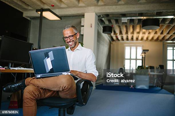 Lächelnd Geschäftsmann Arbeiten Am Laptop Stockfoto und mehr Bilder von Geschäftsinhaber - Geschäftsinhaber, Geschäftsleben, Lächeln