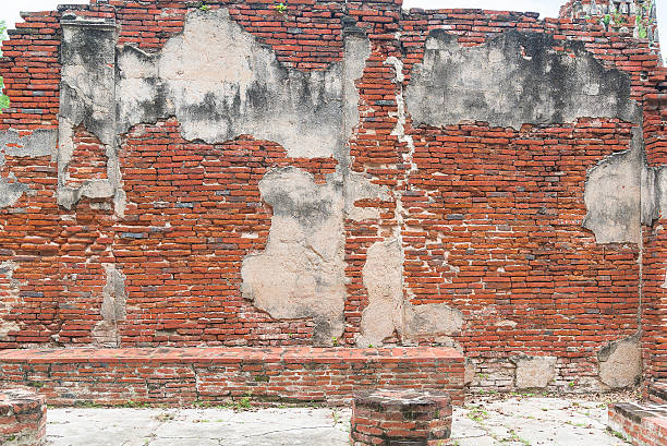 istock ancient old red brick wall fragment with plant background 618761348