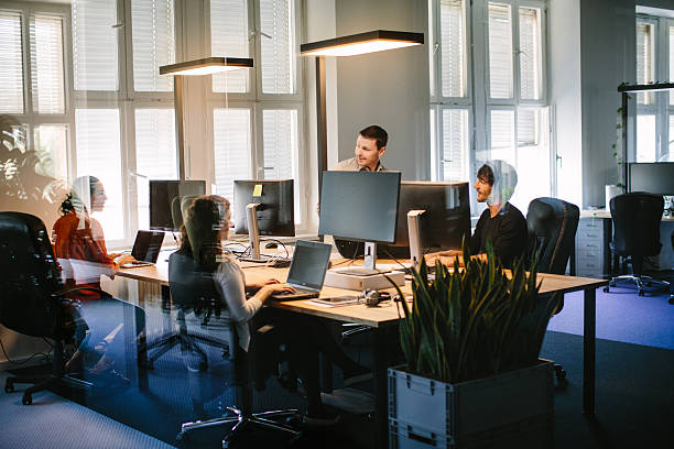 les gens d’affaires travaillant dans des espaces de bureau modernes - cubicle using computer computer office photos et images de collection