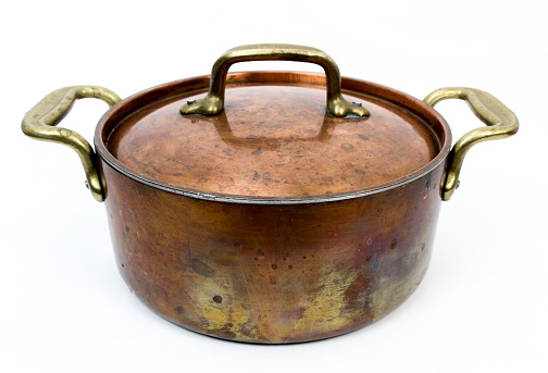 Copper stock pot with lid on a white background