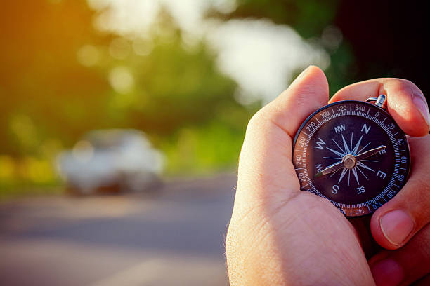 istock Compass in the hand on the nature background. 618764146