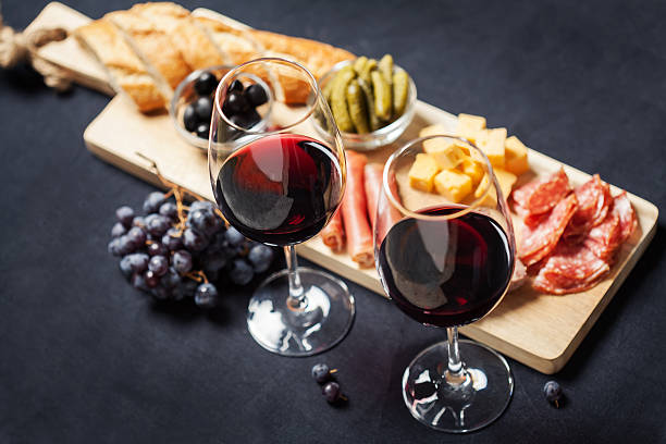 vino rosso con assortimento di salumi sullo sfondo - wine cheese food salami foto e immagini stock