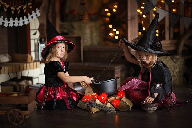 istock Two little Halloween  witches reading conjure above pot   childh 618766466