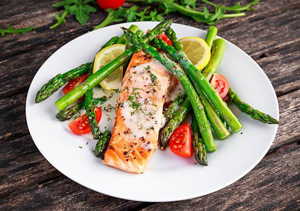 istock Fried salmon with asparagus, tomatoes, lemon, yellow lime on white 618829958