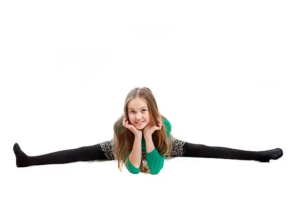 A girl is lying on floor and maiking splitting legs gymnastic, isolated on white background