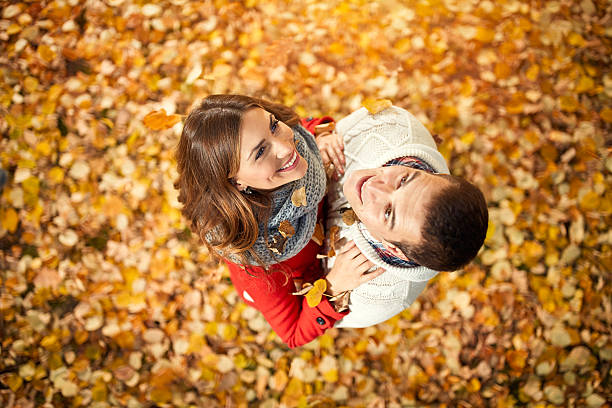 istock couple in love in park with fallen leaves 618831268