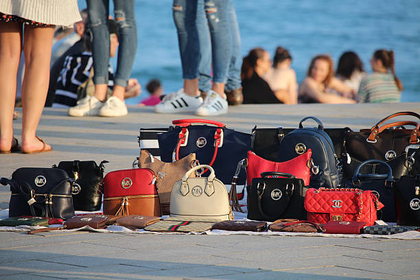 False items sold on the beach Barcelona, Spain - October 29, 2016: Copies of popular brands of women bags sold on the Barceloneta beach brand name photos stock pictures, royalty-free photos & images