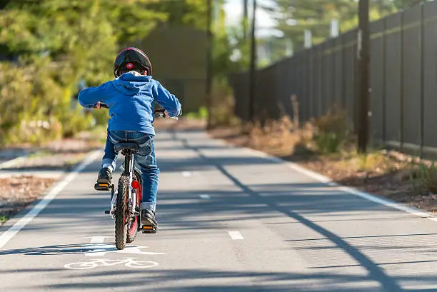 Photo of Kid riding his bicycle on bike lane