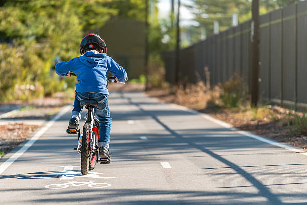 малыш едет на велосипеде по велосипедной дорожке - one kid only фотографии стоковые фото и изображения
