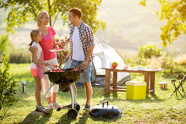 istock smiling parent grilling meat with daughter 618840098