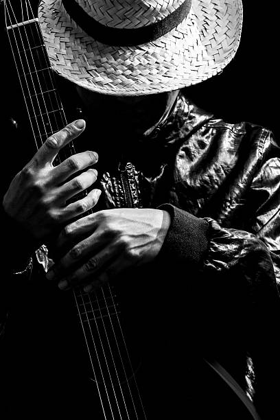 istock musician holding guitar, black and white filter 618843116