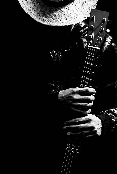 close up of a hand playing spanish guitar on black background. Black and white photography