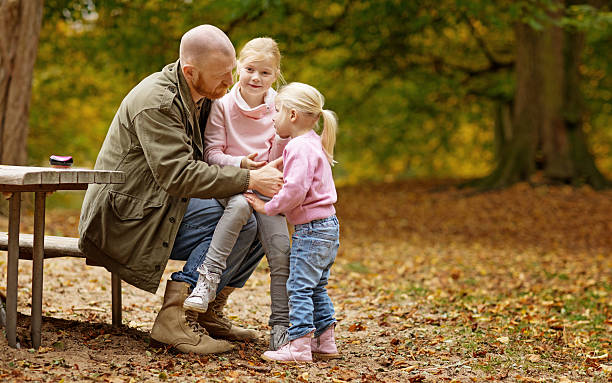 Single father and daughters sitting together on stately autumnal steps Single father and daughters sitting together in autumnal surroundings divorcee stock pictures, royalty-free photos & images