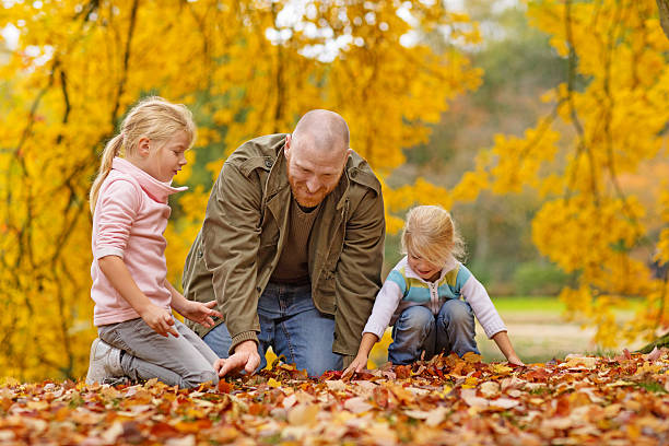 Single father and daughters playing together in autumnal park surroundings Single father and daughters playing together in autumnal park surroundings divorcee stock pictures, royalty-free photos & images