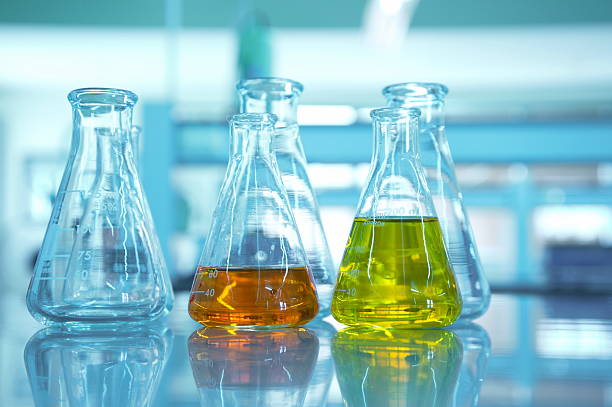 istock yellow and orange flask in science lab with blue background 618848530