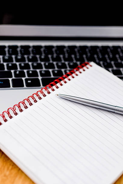 istock Laptop with pen and spiral notebook 618850664