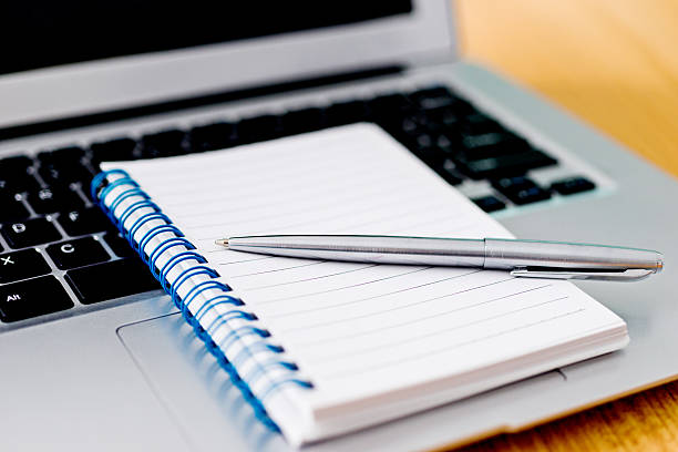 istock Laptop with pen and spiral notebook 618850772