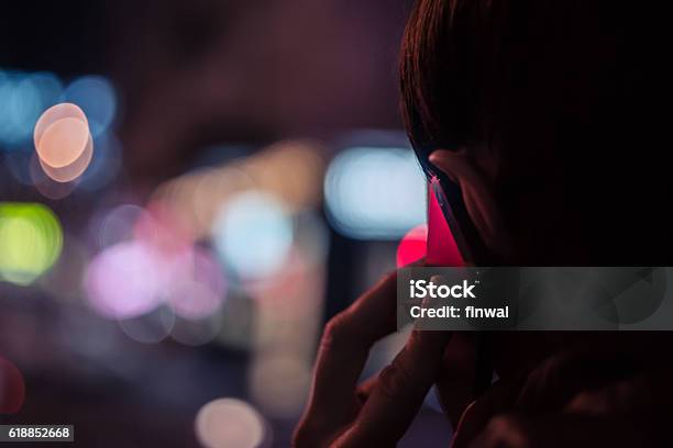 Young Man Talking On Mobile Phone At Night Stock Photo - Download Image Now - Using Phone, Night, Rear View