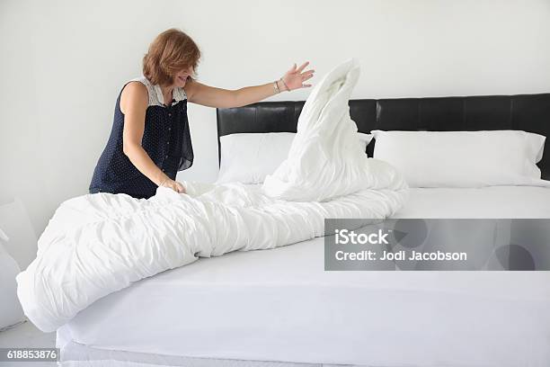 Serieshouse Staging Professional Stager Making Bed In Home For Sale Stock Photo - Download Image Now