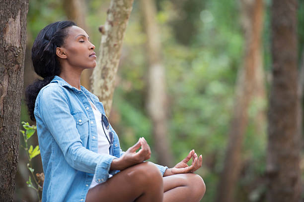 istock African woman meditating in forest. 618854896