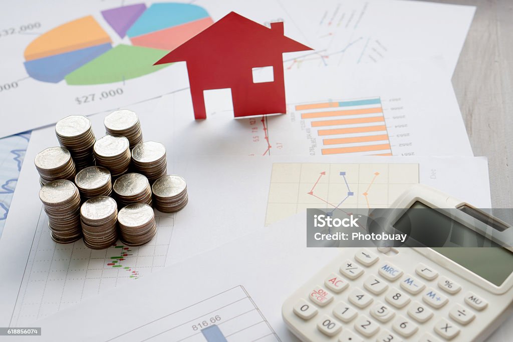 With House Model And Stack Of Coins On Desk House Stock Photo