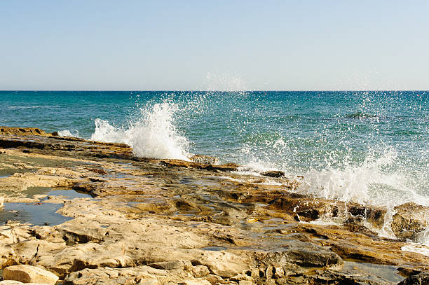 Powerful waves crushing on a rocky Nugal beach in Croatia. Wave splashes breaking on a stony shore. Scenic seascape view. Card, banner, travel catalog photo. Copy space. Selective focus.
