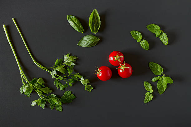 grünes gemüse um drei rote tomaten - cherry tomato image raw colors stock-fotos und bilder