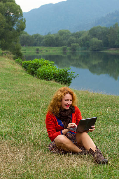 istock Woman outdoors in park using a laptop deals 618858856