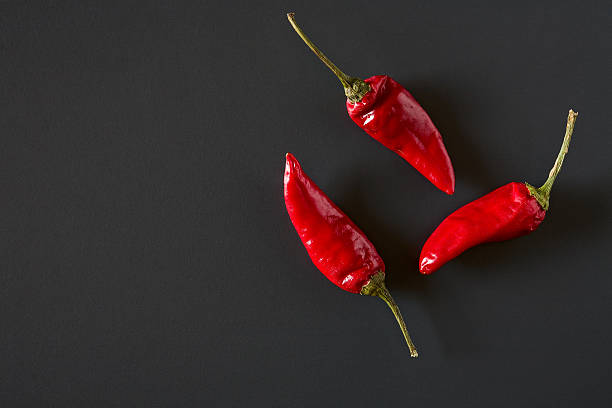 istock Red hot chili peppers over a dark background 618859088