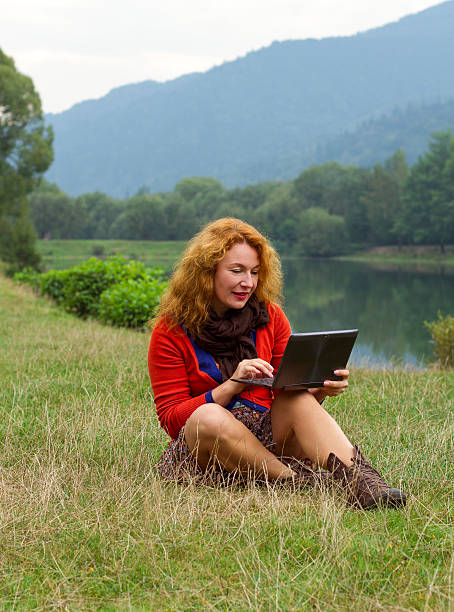 istock Woman outdoors in park using a laptop deals 618859278