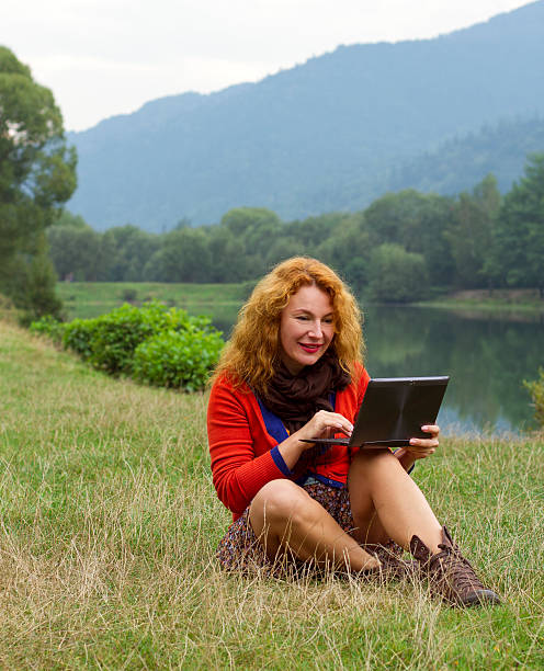 istock Woman outdoors in park using a laptop deals 618859604