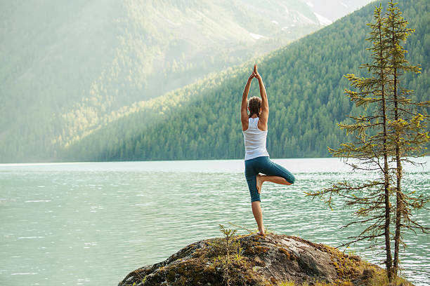 Giovane donna praticare yoga in montagna Lago - foto stock