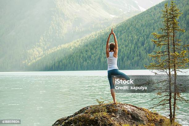 Young Woman Is Practicing Yoga At Mountain Lake Stock Photo - Download Image Now - Yoga, Mountain, Lake