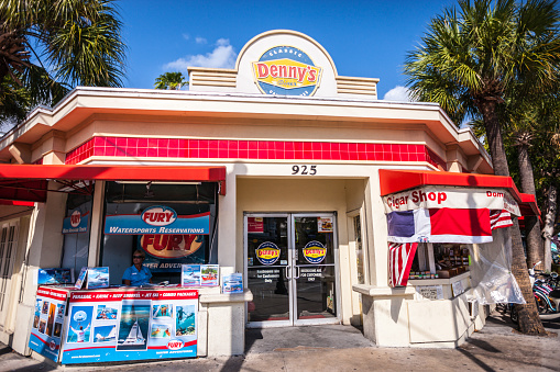 Key West, USA - January 9, 2015: Denny's Diner on Key West, Florida, USA. At the entrance woman selling sightseeing packages for tourists, including  kayaking, parasailing, snorkeling etc. 
