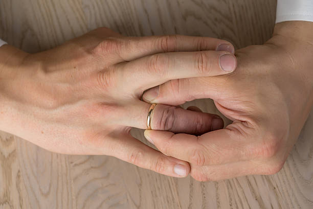 istock Divorce, separation: hands of man removing wedding or engagement ring 618863246