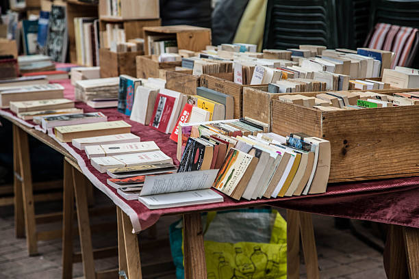 secondhand books on a stall in a French market place Second hand books for sale in a French market in Nyons, Provence newspaper titles stock pictures, royalty-free photos & images