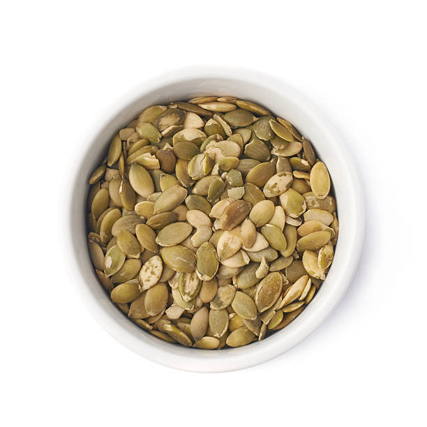 istock White cup filled with pumpkin seeds 618864702