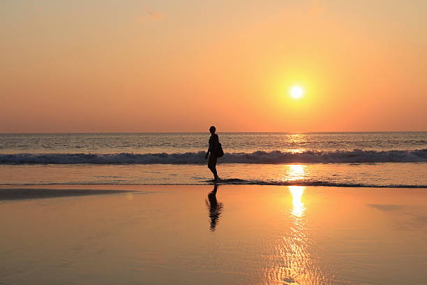 istock female  on the beach at sunset time 618867794