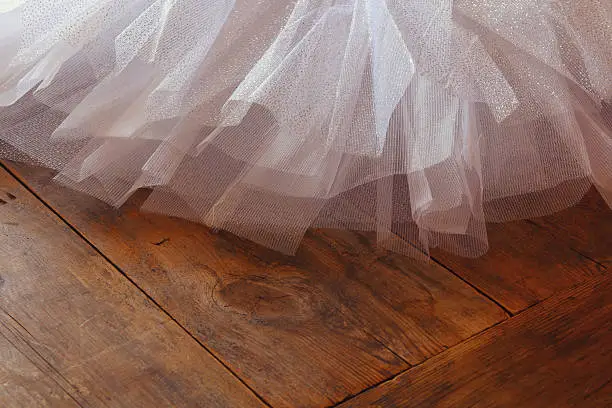 Photo of White ballet tutu on wooden floor