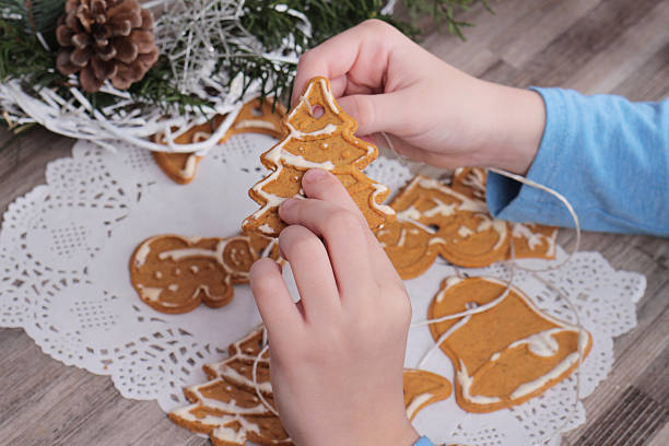istock Kid making christmas tree decoration from gingerbread cookie close up 618868698