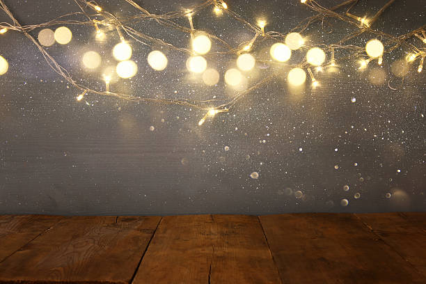 istock empty table in front of Christmas warm gold garland lights 618869782