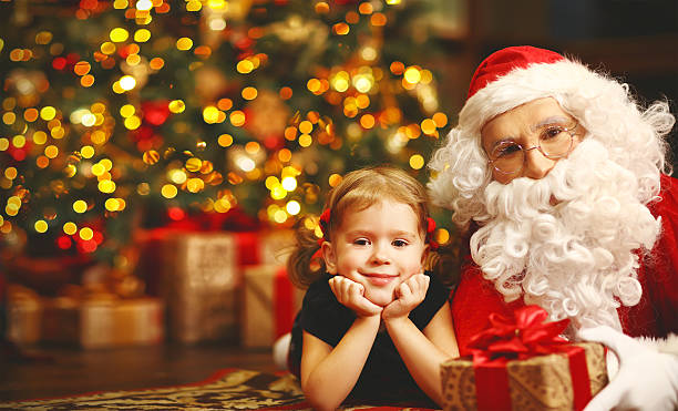 istock happy child girl hugging Santa 618870846