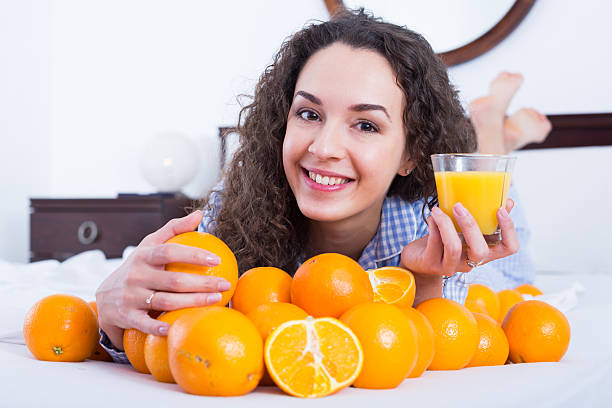 jovem mulher com laranja suco e frutas - routine foods and drinks clothing household equipment imagens e fotografias de stock